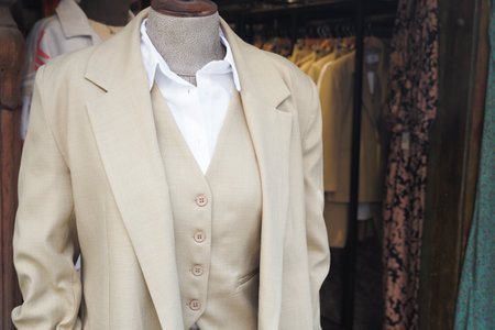 An Elegant Beige Suit is beautifully displayed in a Fashion Boutique Showcase for all to seeの写真素材