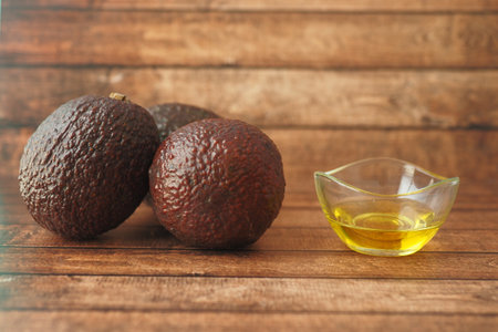 Delicious Fresh Avocados and Olive Oil on a Beautiful Wooden Background for Cookingの写真素材