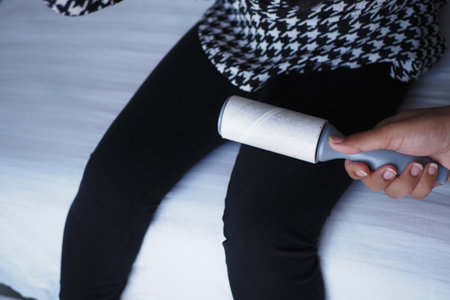 Utilizing a lint roller on dark pants ensures a neat and clean look.の写真素材