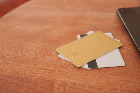 A collection of cards elegantly displayed on a wooden table along with a laptop.