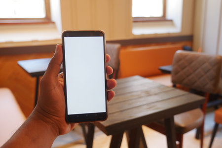 A Smartphone Display Set Against the Backdrop of a Modern Cafe Environment and Atmosphere