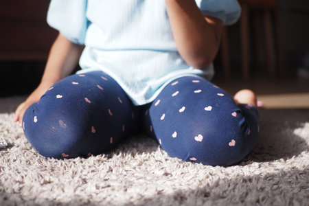 child sitting W posture on the floor .の写真素材