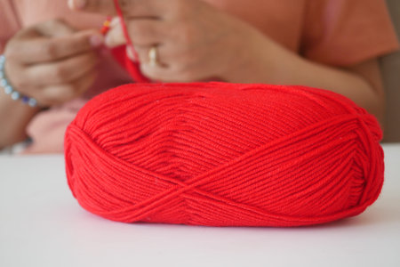 Hand close up crocheting with a hook, wool yarn, creative craft