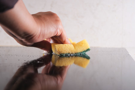 hand with cloth cleaning electric stove.の写真素材