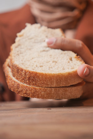 A Delicious Loaf of Freshly Sliced Bread Being Held by a Persons Hand Enthusiasticallyの写真素材
