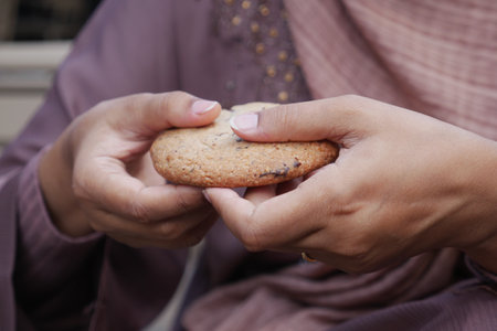 woman hand cracking a sweet cookiesの写真素材