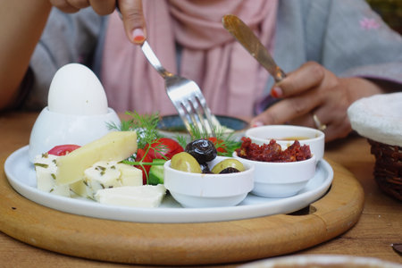 A plate of Delicious Assorted Cheese and Accompaniments artfully arranged on a Rustic Tableの写真素材