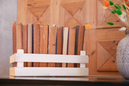Cozy reading nook with a wooden bookshelf, books, and flowers, perfect for literature loversの写真素材