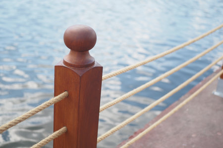 A rustic wooden post and rope are situated gracefully by the peaceful waters edgeの写真素材