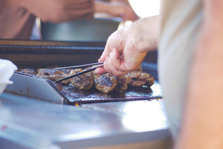 Grilling Delicacies A Skilled Chef Cooking Delicious Burgers on a Charcoal BBQ Grillの写真素材