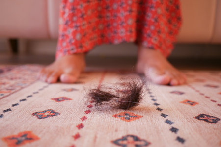 women lost hair drops on carpetの写真素材