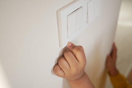 child finger turning on lighting switch with copyspaceの写真素材