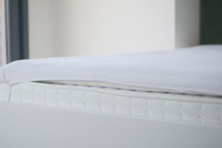 Bed with white orthopedic mattress in a room.の写真素材