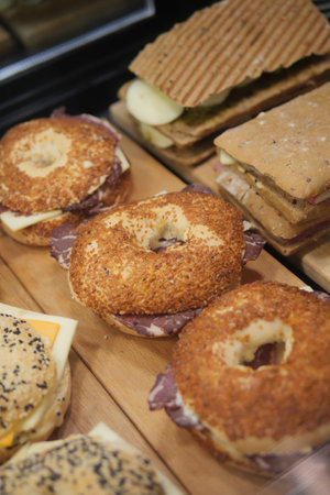 An Appealing Display of Tasty Bagels and Scrumptious Snacks Located in a Cozy Bakery Environmentの写真素材