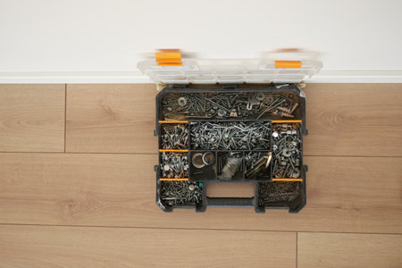 A wood flooring with a toolbox containing screwsの写真素材