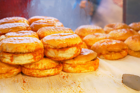Freshly made, warm, and glazed doughnuts at a charming local bakery, ready for you to enjoyの写真素材