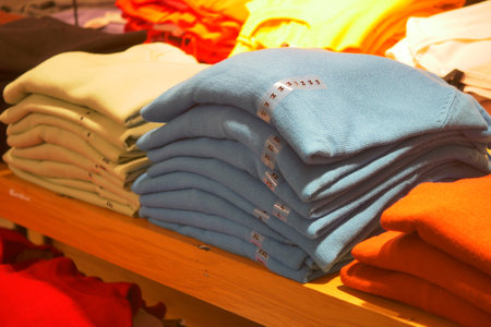 A vibrant display of stacked sweaters in retail attracts customers with beautiful colorsの写真素材
