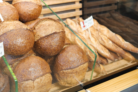 A Wonderful Selection of Artisanal Bread is Beautifully Displayed in the Bakery Display Caseの写真素材