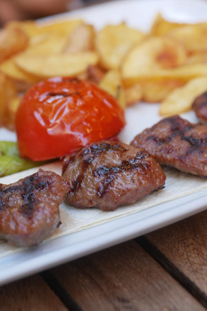 Grilled Meat With Roasted Tomato and Fries on Plateの写真素材