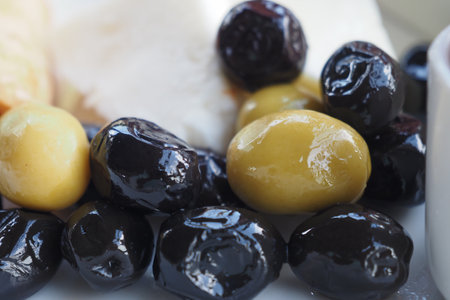 Collection of black and green olives with leaves.の写真素材