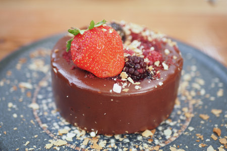 Indulgent Decadent Chocolate Cake topped with Fresh Seasonal Berries and a Crunchy Toppingの写真素材
