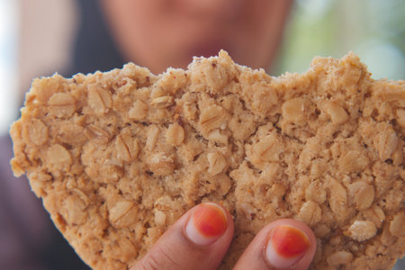 A Delicious Oatmeal Snack Bar Comfortably Held in My Hand, Perfectly Ready to Savor and Enjoyの写真素材