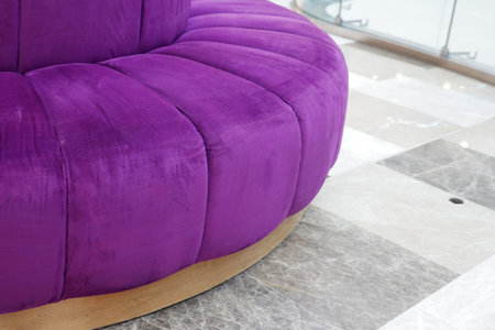 This stylish purple upholstered couch features a unique and elegant design with graceful curvesの写真素材