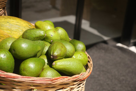 Delicious Fresh Green Avocados Beautifully Arranged in a Basket for Your Cooking Needsの写真素材
