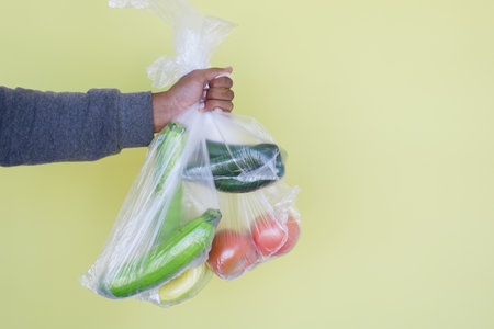 Hand Carrying Fresh Vegetables in Clear Plastic Bag, Healthy Eating and Zero Waste Conceptの写真素材