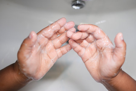 child making a cleansing gesture with soap and water on handsの写真素材