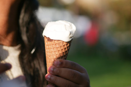 A delicious ice cream cone held in hand, perfect for enjoying on a sunny summer day