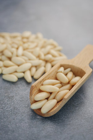 Wooden Spoon Filled with Fresh Raw Pine Nuts on Grey Backgroundの写真素材