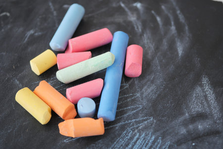 Brightly Colored Chalk Pieces Scatter Across a Chalkboard Surface