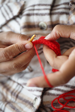 Hand close up crocheting with a hook, wool yarn, creative craftの写真素材