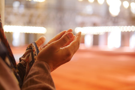 Muslim young woman in hijab is praying in mosque.の写真素材