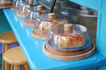 A Showcase of Delicious and Tempting Pastries Under a Glass Cloche Displayの写真素材