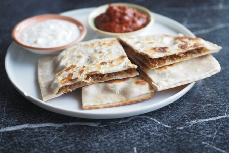A Delicious Indian Flatbread Served with Various Dips and Saucesの写真素材