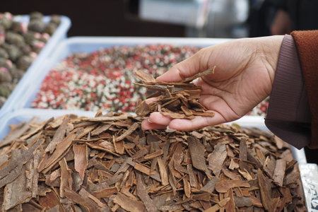 Hand Holding Various Natural Spices at a Vibrant Market Stallの写真素材