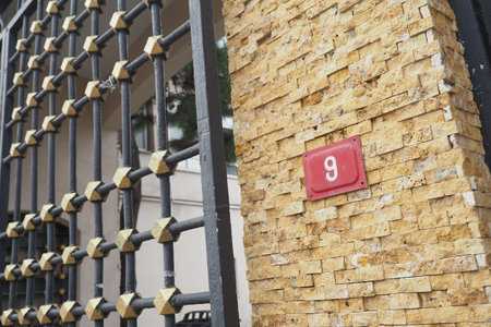 An Elegant Gate Design Complemented by a Number 9 House Sign Displayの写真素材