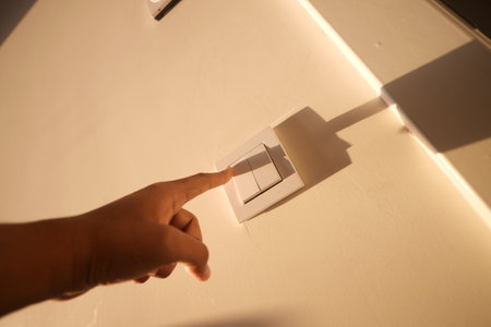 A finger turning on lighting switch .の写真素材
