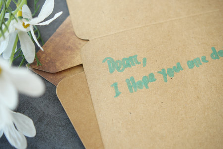 A lovely handwritten note on Kraft paper with floral accents for occasionsの写真素材