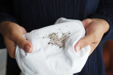 women holding white color dirty shirt, showing making stainの写真素材