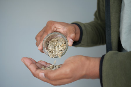 pouring sun flower seeds from a containerの写真素材