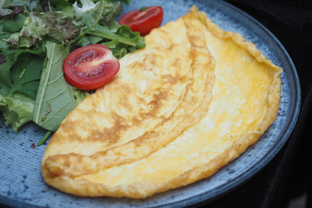 A Delicious Golden Omelette Beautifully Served on a Plate, Perfectly Ready to Be Enjoyedの写真素材