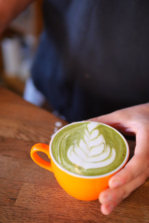 Artistic Green Latte presented in a strikingly vibrant orange cupの写真素材