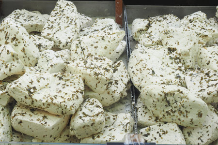 A Delicious Fresh HerbInfused Cheese Block, Perfectly Positioned with a Knife on Top for Servingの写真素材