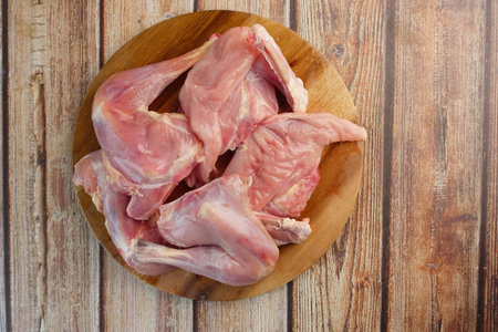 A Set of Raw Chicken Wings Situated on a Wooden Cutting Board Surfaceの写真素材