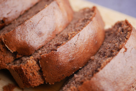 Irresistibly Delicious Chocolate Loaf Cake Slices Arranged on a Wooden Boardの写真素材