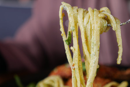 Delicious Pasta Twirled Artfully on a Fork with Fresh Garnish and Herbsの写真素材