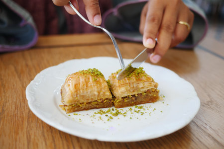 woman eating dessert baklava on a plateの写真素材